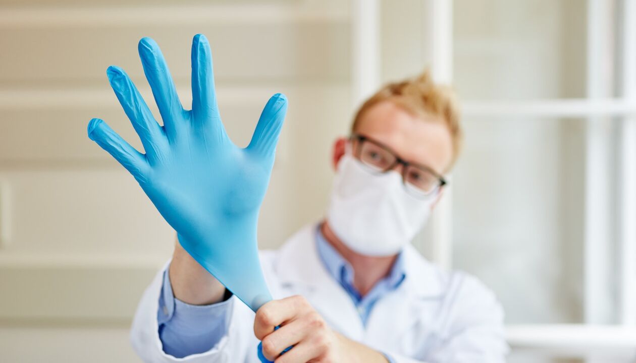 gydytojas užsimauna pirštines masažui, kad išvengtų prostatito